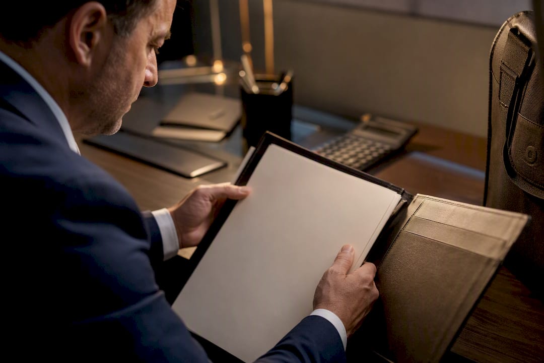 Hands opening a trust deed folder
